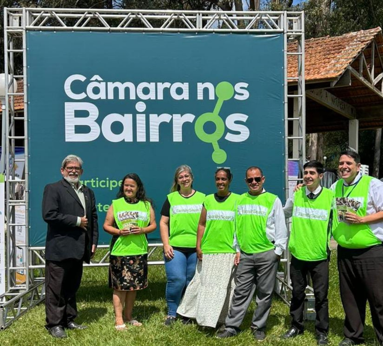 Participantes reunidos diante de um painel em atividade comunitária.